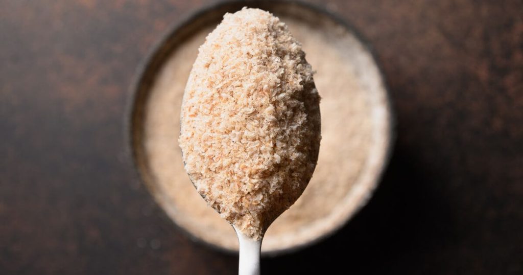 Psyllium Husk in Spoon on Brown Background.